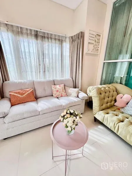 Detached House for rent - Bright living room with large windows, a gray sofa, tufted chaise and a pink round coffee table.