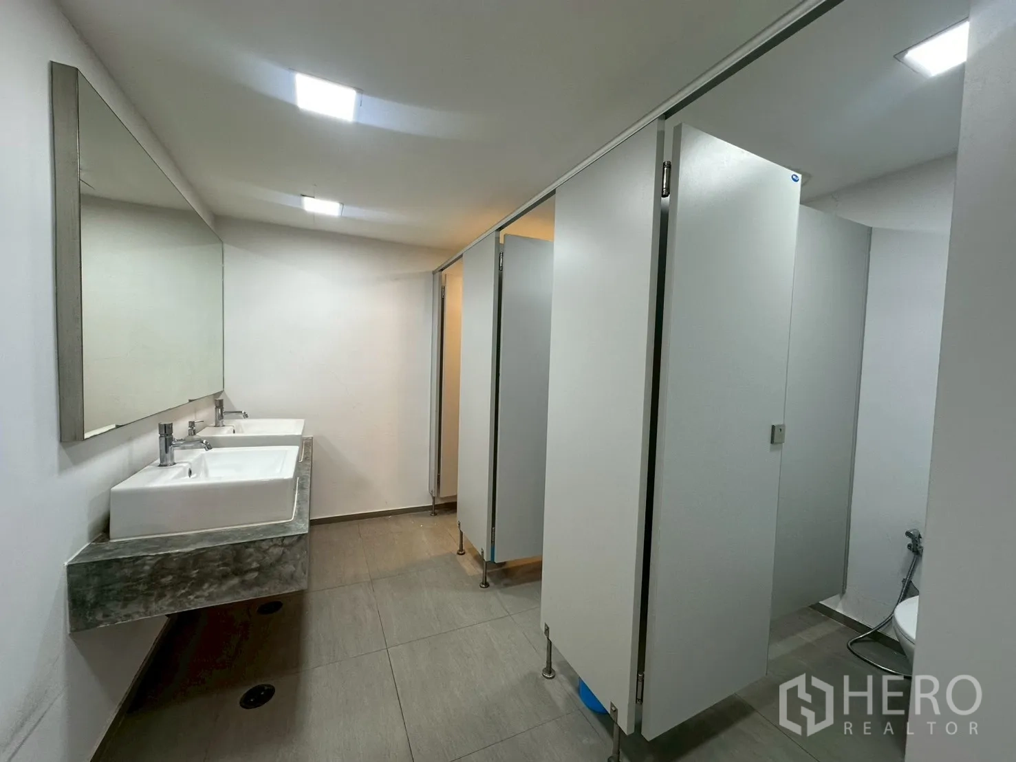 Office Space for rent - Shared washroom with dual basins and toilet cubicles.