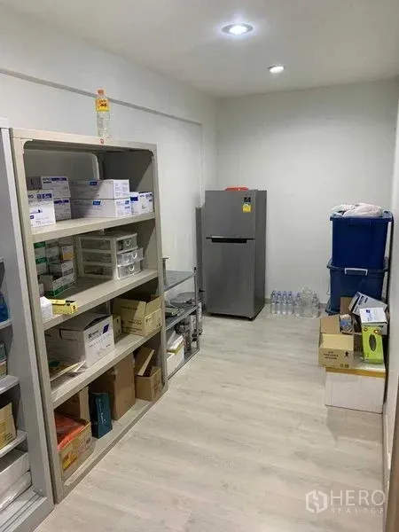 零售空间 出租在Pathum Wan, Bangkok - 储物间配开放式货架、纸箱和冰箱，浅色木地板。