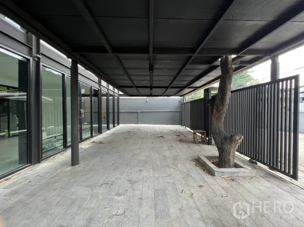 บ้าน ให้เช่าหรือขายในPhra Khanong, Bangkok - ชานระเบียงยาวและลานจอดรถ พร้อมรั้วซี่และแปลงต้นไม้