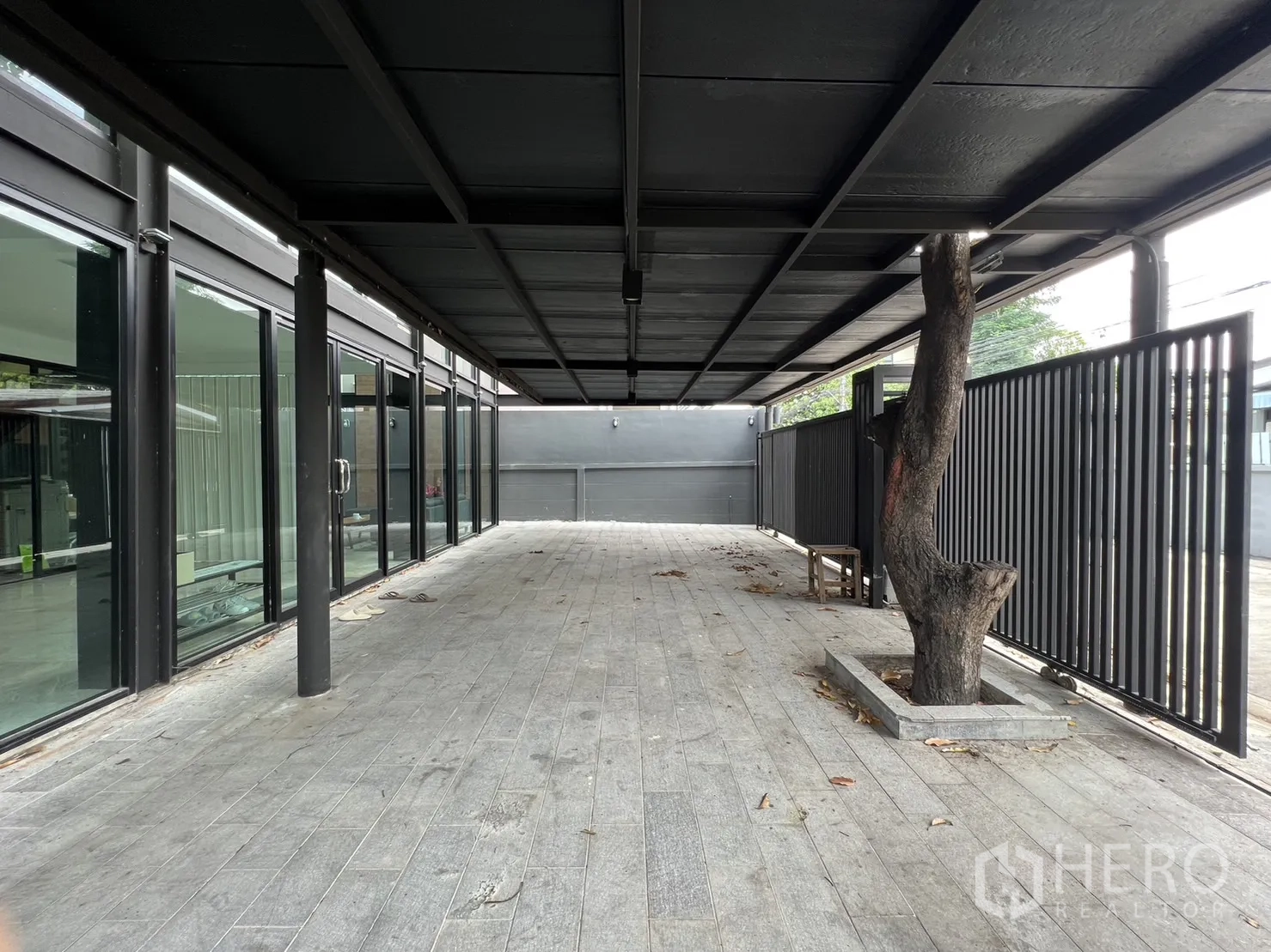 บ้าน ให้เช่าหรือขายในPhra Khanong, Bangkok - ชานระเบียงยาวและลานจอดรถ พร้อมรั้วซี่และแปลงต้นไม้