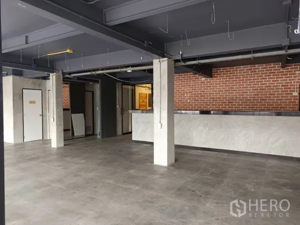 พื้นที่ขายปลีก ให้เช่าในWatthana, Bangkok - พื้นที่ขายพร้อมเคาน์เตอร์บริการ ประตูหลายบาน และผนังอิฐ.