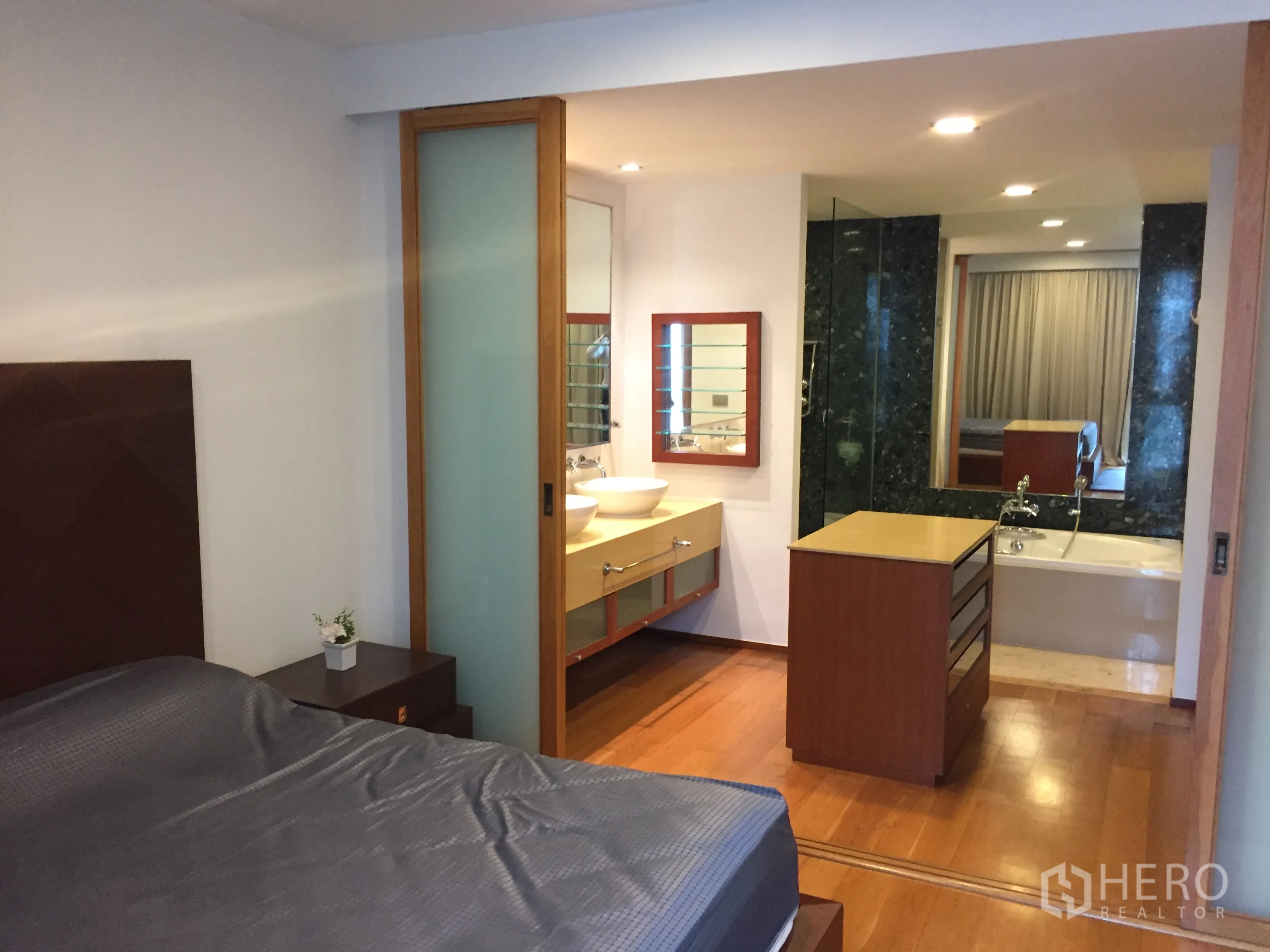 公寓 出租在Khlong Toei, Bangkok - 主卧带独立卫浴，配浸泡浴缸、台盆与温润木地板