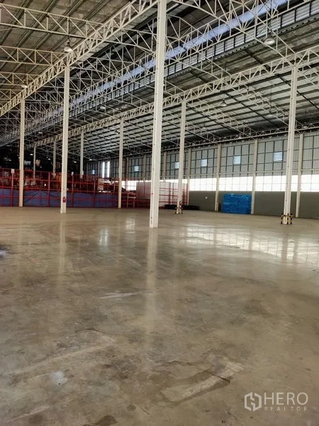 Warehouse for rent in Bang Sue, Bangkok - Spacious warehouse interior with high steel truss ceiling, polished concrete floor, and open storage area in Bang Sue.