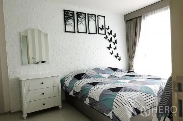 公寓 出租在Khlong Toei, Bangkok - 卧室带白色砖纹背景墙与蝴蝶装饰，大窗配遮光帘。