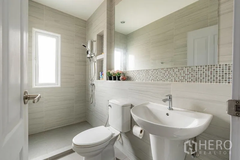 บ้าน ให้เช่าหรือขายในBang Khen, Bangkok - ห้องน้ำสมัยใหม่ ฝักบัวแบบวอล์กอิน สุขภัณฑ์สีขาว และแถบโมเสกตกแต่ง