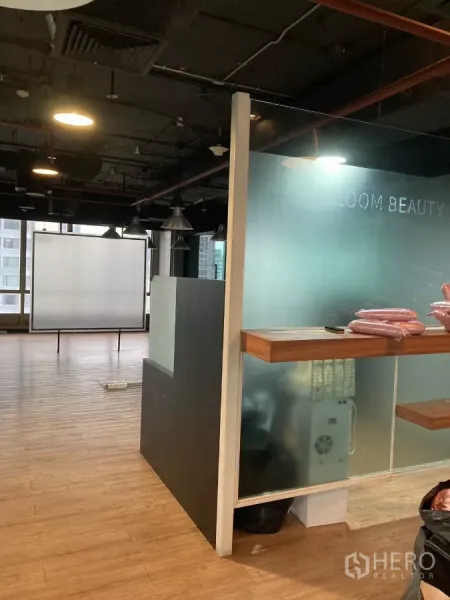 Office Space for rent in Watthana, Bangkok - Reception counter with frosted glass beside open-plan area and projector screen in a Watthana office.