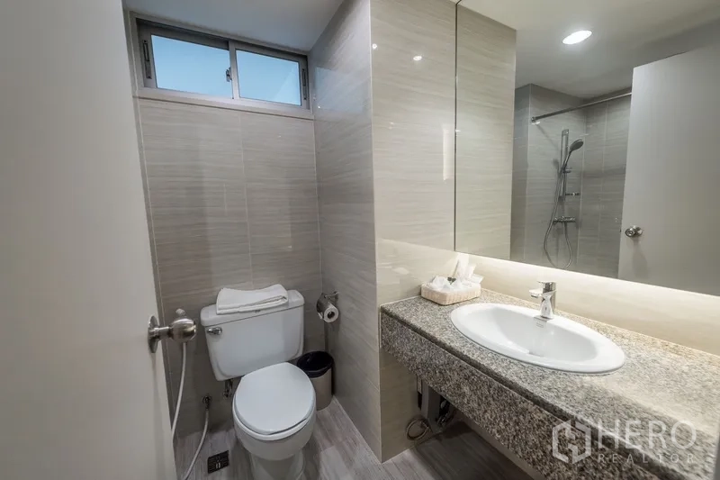 房间 出租在Yan Nawa, Bangkok - 现代浴室，带大镜子、花岗岩台面、马桶与淋浴间。