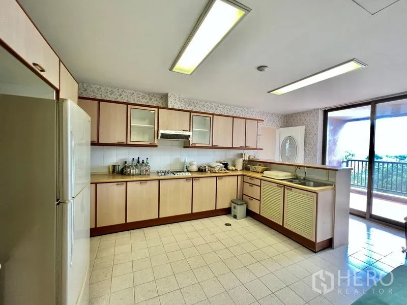 คอนโด ขายในPak Kret, Nonthaburi - มุมครัวแสดงเตาแก๊ส เคาน์เตอร์ยาว และประตูกระจกออกระเบียง