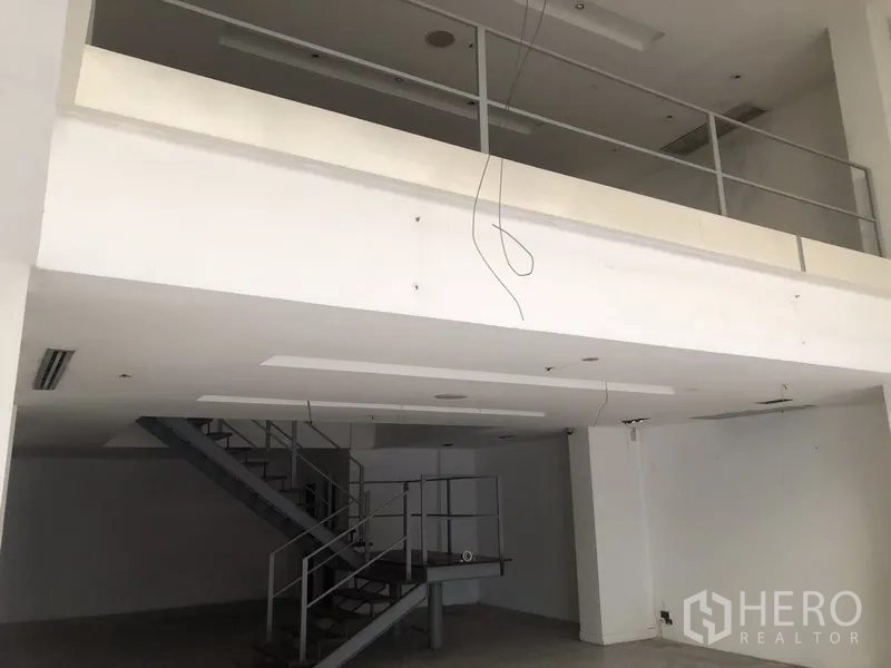 Home Office for rent in Khlong Toei, Bangkok - Open-plan home office interior with mezzanine level and metal staircase.