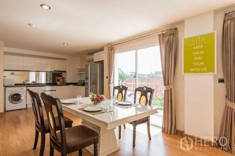 คอนโด ให้เช่าในKhlong Toei, Bangkok - โต๊ะอาหารริมประตูกระจกบานเลื่อน ถัดจากครัวสมัยใหม่พร้อมตู้เย็น เตา และเครื่องซักผ้า