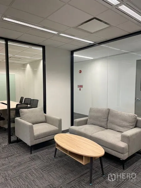 Office Space for rent in Dusit, Bangkok - Modern office lounge with sofa and armchair beside a glass-walled meeting room.