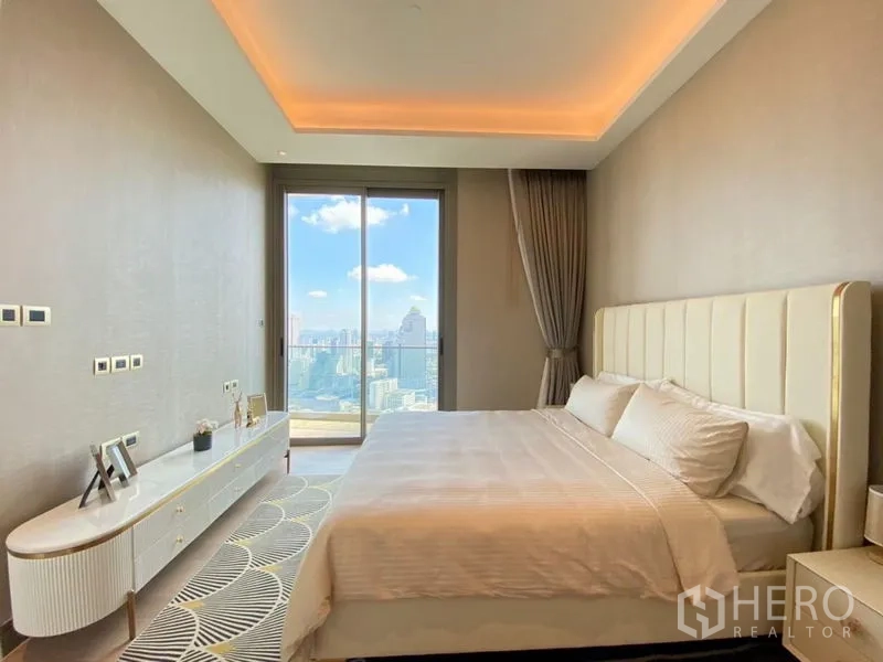 Condominium for rent in Khlong San, Bangkok - Spacious bedroom with ambient ceiling lights and balcony framing skyline views.