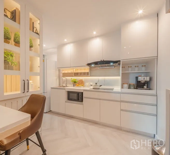 Condominium for sale in Yan Nawa, Bangkok - Wide kitchen perspective with illuminated cabinets, barstool, and open shelving.