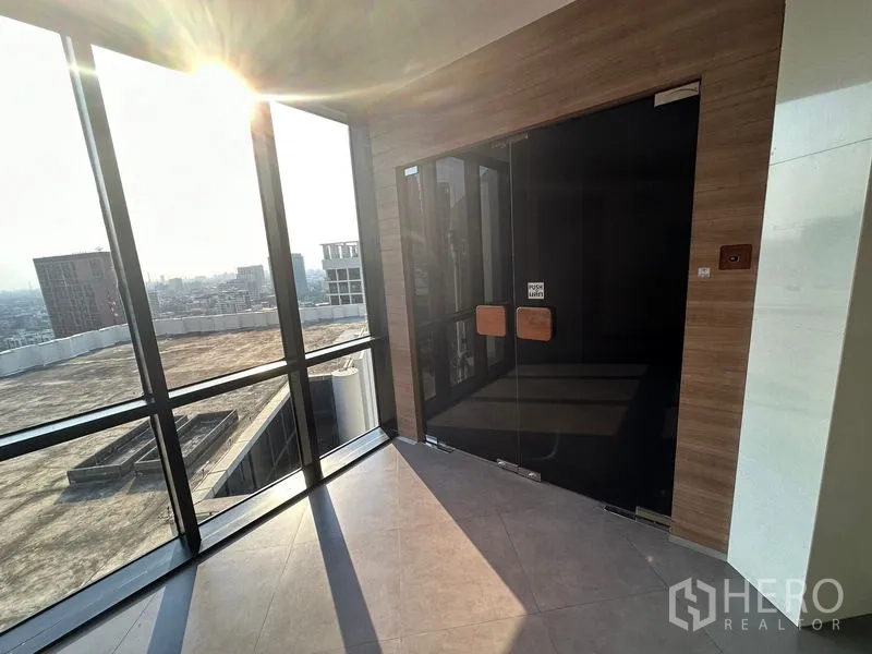 สำนักงาน ให้เช่า - โถงทางเข้าแบบประตูกระจกคู่ หน้าต่างบานใหญ่ล้อมรอบ พื้นกระเบื้อง มองเห็นวิวตึกจากชั้นสูง