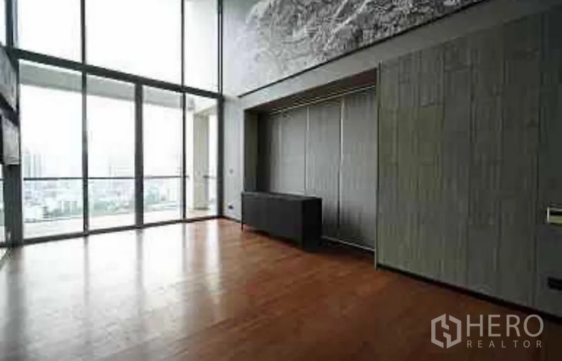 公寓 出租在Sathon, Bangkok - 宽敞客厅，落地玻璃与阳台，可眺望城市景观，木地板温润。