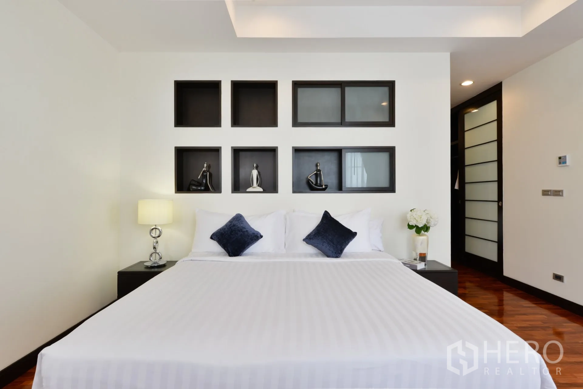 Apartment for rent in Watthana, Bangkok - Bedroom close-up showing wall display niches above the bed with soft lighting.