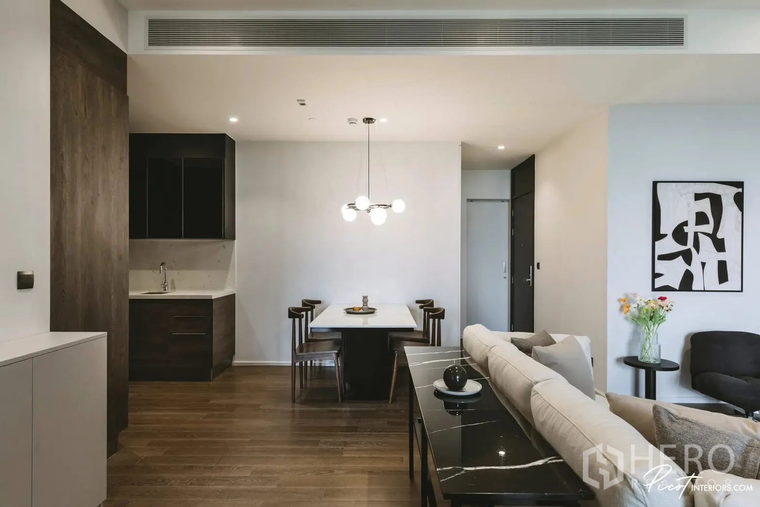 Condominium for rent in Pathum Wan, Bangkok - Open dining space with modern pendant lighting and wood flooring.