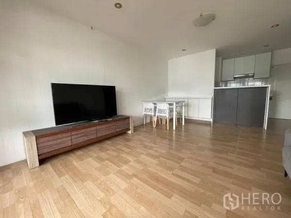 คอนโด ให้เช่าในWatthana, Bangkok - ห้องนั่งเล่นโอเพนแปลน พื้นไม้ ตู้วางทีวี และครัวขนาดกะทัดรัด