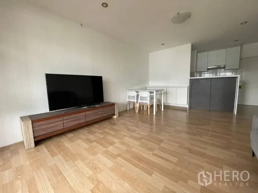 คอนโด ให้เช่าในWatthana, Bangkok - ห้องนั่งเล่นโอเพนแปลน พื้นไม้ ตู้วางทีวี และครัวขนาดกะทัดรัด