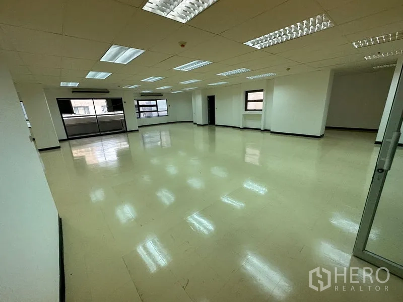 Office Space for rent in Pathum Wan, Bangkok - Bright open office space with cream vinyl floors, white walls and rows of fluorescent lights.