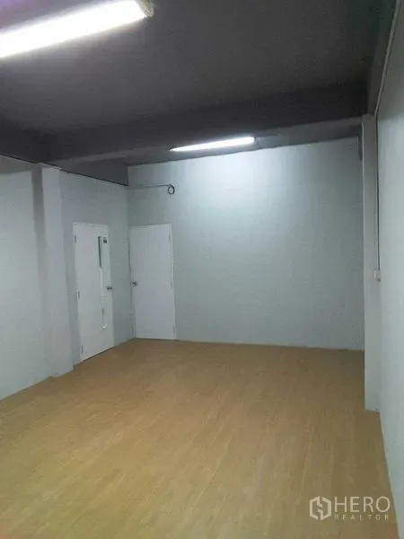 店屋 出租在Khlong Toei, Bangkok - 整洁开放房间，仿木地板、白色门与日光灯。