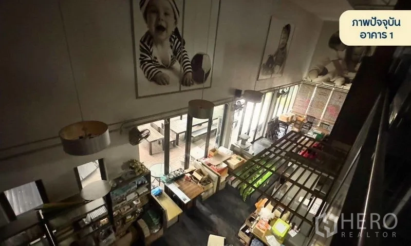 零售空间 出租在Wang Thonglang, Bangkok - 从夹层俯瞰双层挑高展厅，设展示架与大窗户。