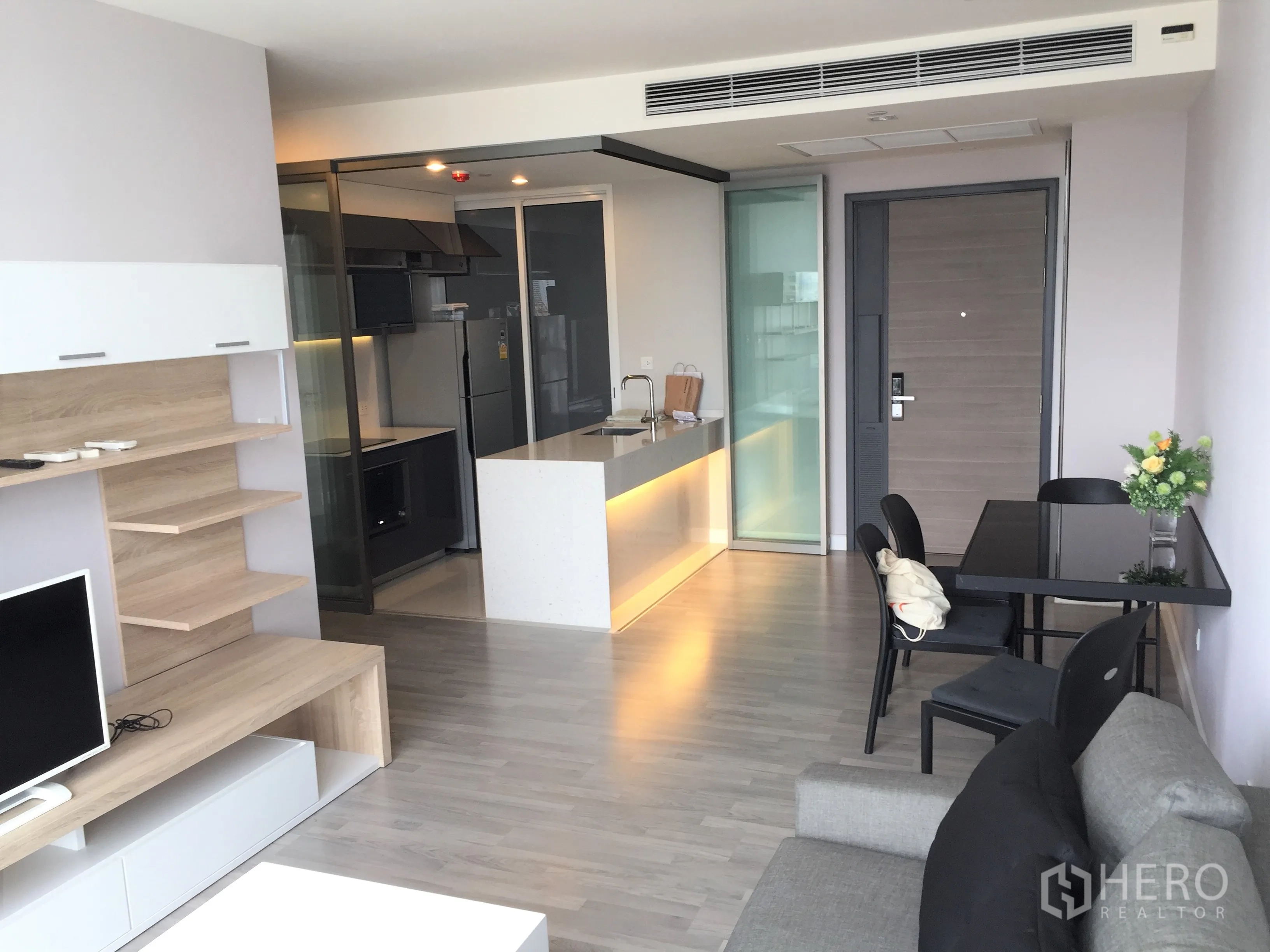 公寓 出租在Bang Rak, Bangkok - 开放式起居与用餐区，带中岛与玻璃隔断的现代厨房，邦拉区两卧公寓。