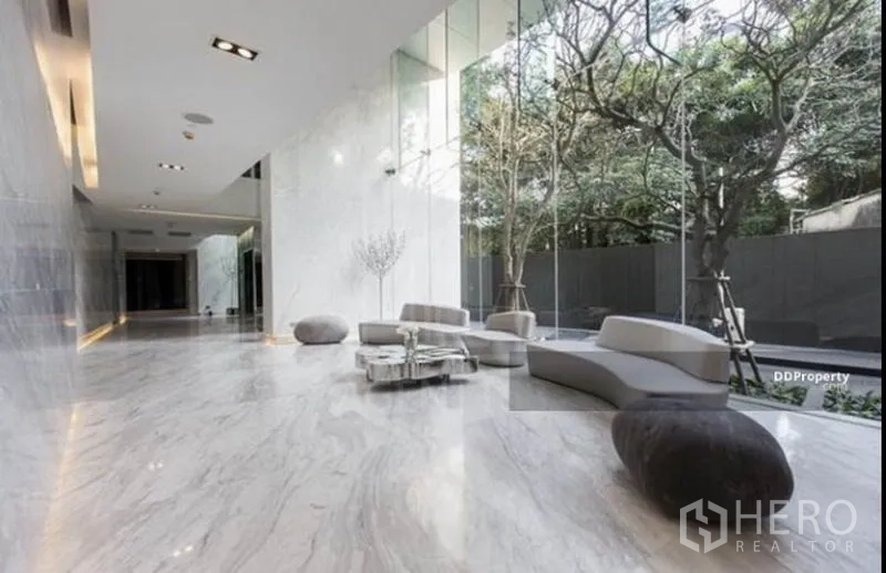 Condominium for rent in Watthana, Bangkok - Elegant marble lobby with designer seating and garden outlook.