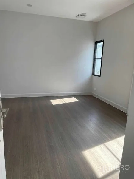 Detached House for sale in Saphan Sung, Bangkok - Upper‑floor bedroom with minimalist décor and a corner window.