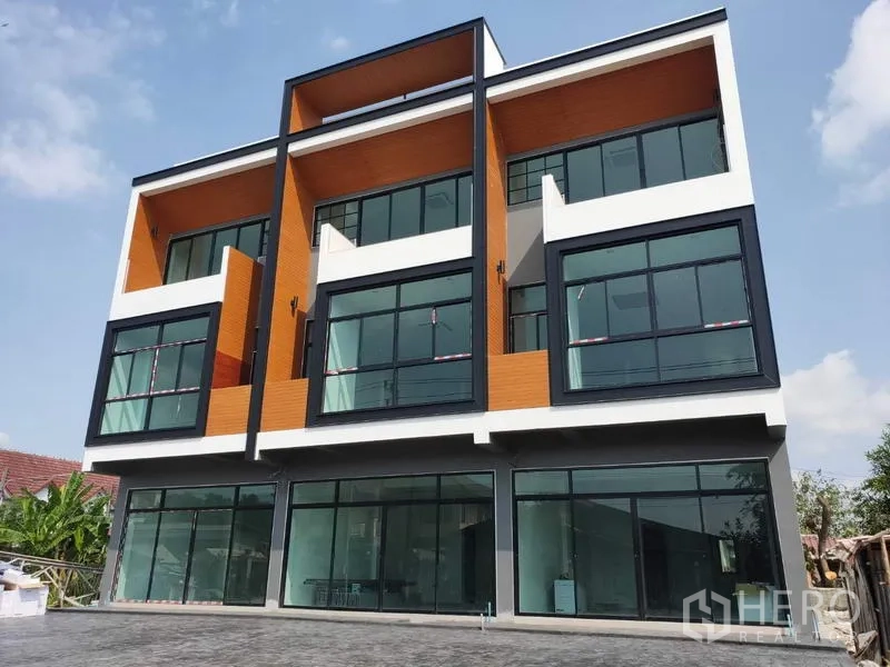 Home Office for sale in Lam Luk Ka, Pathum Thani - Modern three-storey home office facade with large glass frontage and balconies.