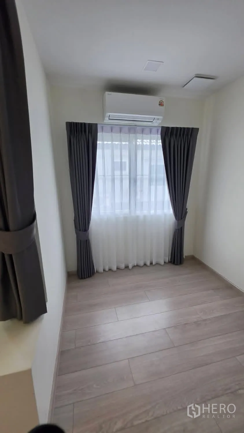 Detached House for rent in Bang Phli, Samut Prakan - Small bedroom with AC, sheer and blackout curtains, and wood floors.