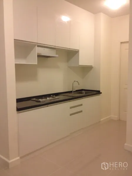 联排别墅 出租在Watthana, Bangkok - 现代白色橱柜厨房，黑色台面与水槽。