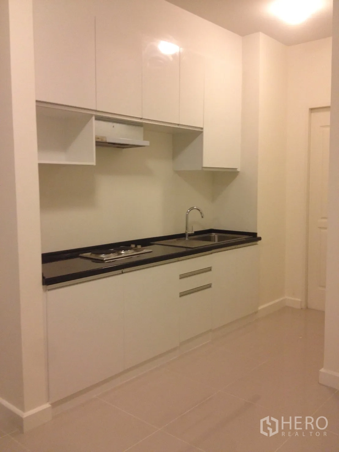 联排别墅 出租在Watthana, Bangkok - 现代白色橱柜厨房，黑色台面与水槽。