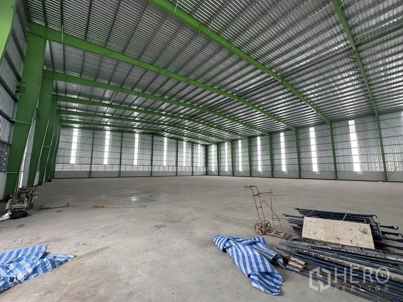 คลังสินค้า ให้เช่าในWang Noi, Phra Nakhon Si Ayutthaya - ฮอลล์โกดังมีรถเข็นและวัสดุบนพื้น ช่องแสงสูงให้แสงธรรมชาติ