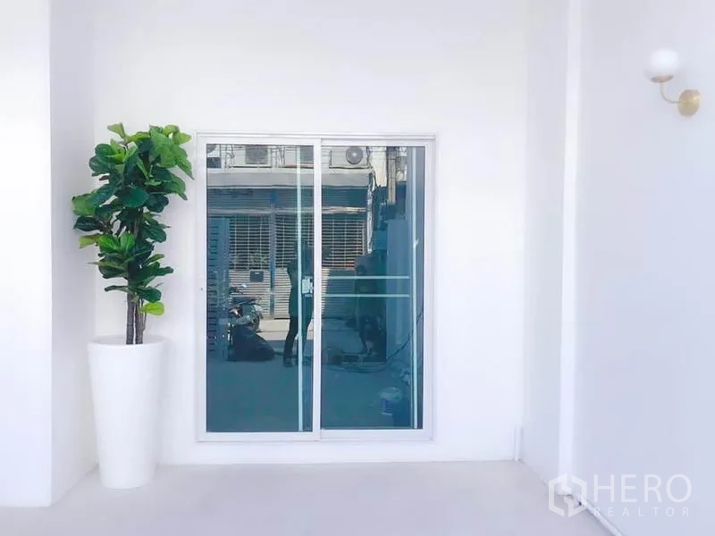 带办公室的家 出租或出售在Phra Khanong, Bangkok - 入口区的推拉玻璃门与装饰性绿植花盆。