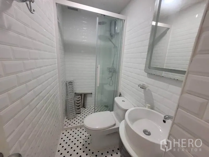 公寓 出租在Watthana, Bangkok - 第二卫浴紧凑，圆形面盆、坐便与玻璃移门淋浴。