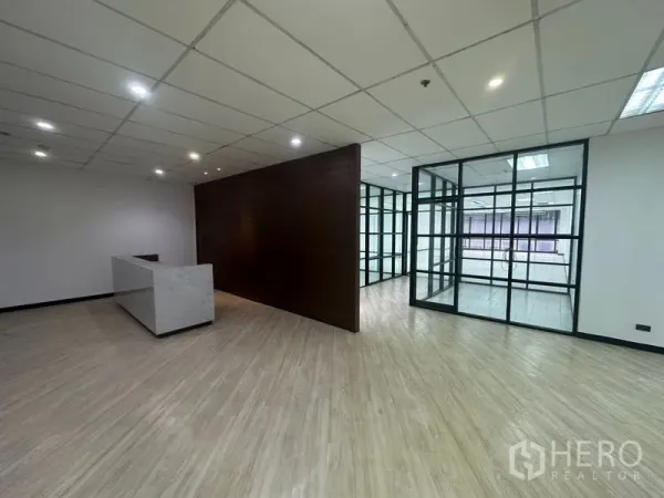 办公空间 出租在Din Daeng, Bangkok - 接待区，石材前台、木质背景墙与玻璃会议室。