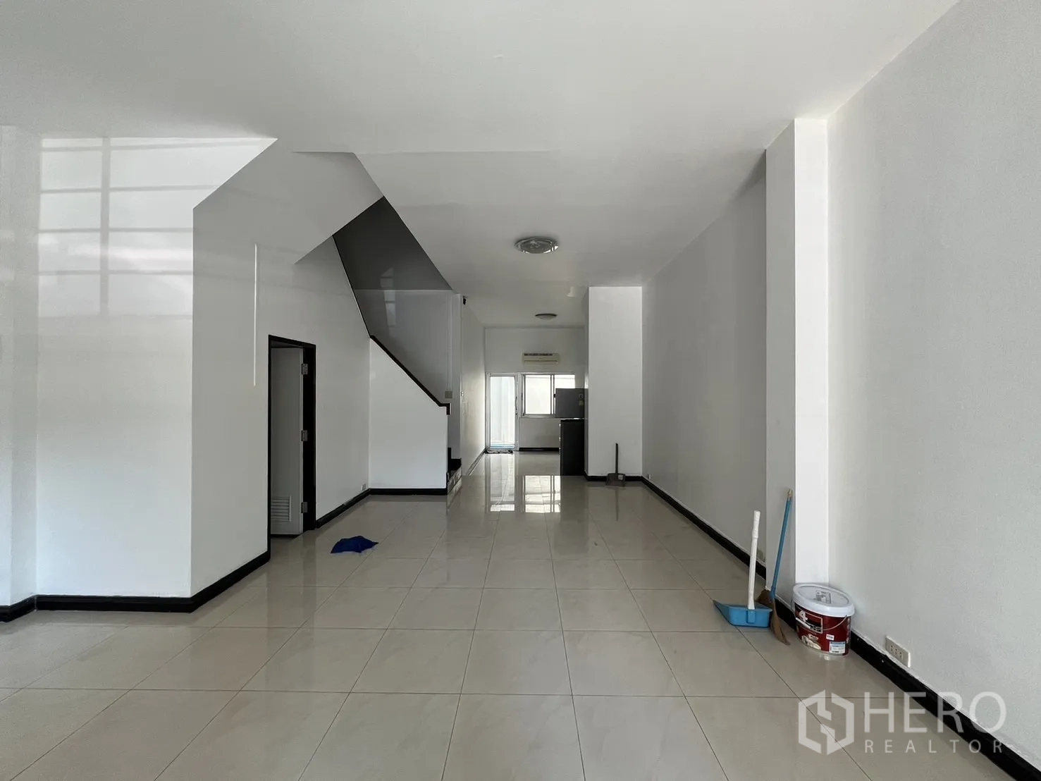 ทาวน์เฮาส์ ให้เช่าในKhlong Toei, Bangkok - ชั้นล่างแบบโอเพ่นสเปซ พื้นกระเบื้องเงา บันไดขึ้นชั้นบนและโถงยาวสู่ครัว