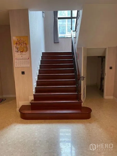 Detached House for sale in Mueang Samut Prakan, Samut Prakan - Wide wooden staircase with handrail and a window bringing natural light into the foyer.