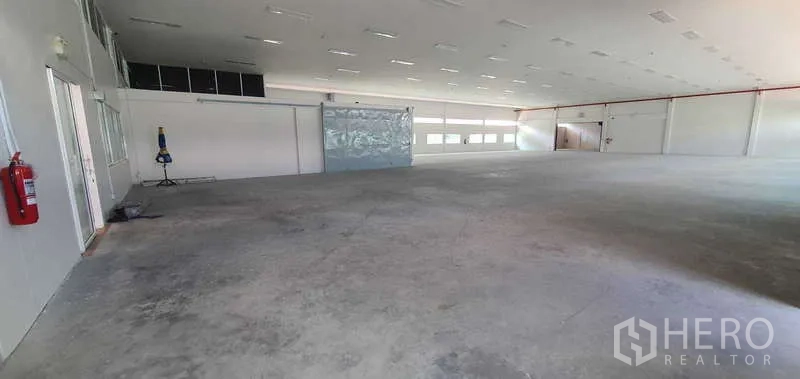 工厂 出租或出售在Lat Krabang, Bangkok - 开阔的工厂大厅，混凝土地面、白色墙面与成排顶灯。