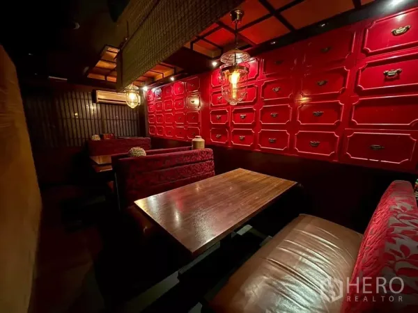 店屋 出租在Watthana, Bangkok - 温馨卡座用餐区，木桌、红色柜墙和吊灯。