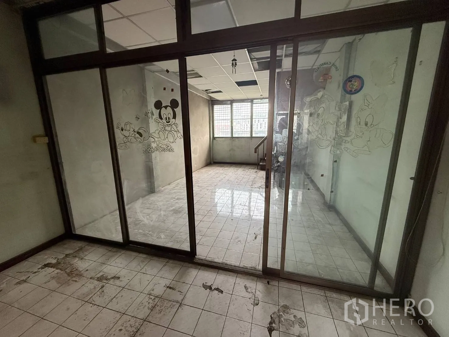 店屋 for rent in Khlong Toei, Bangkok - 透过推拉玻璃门看向采光充足的瓷砖房间。