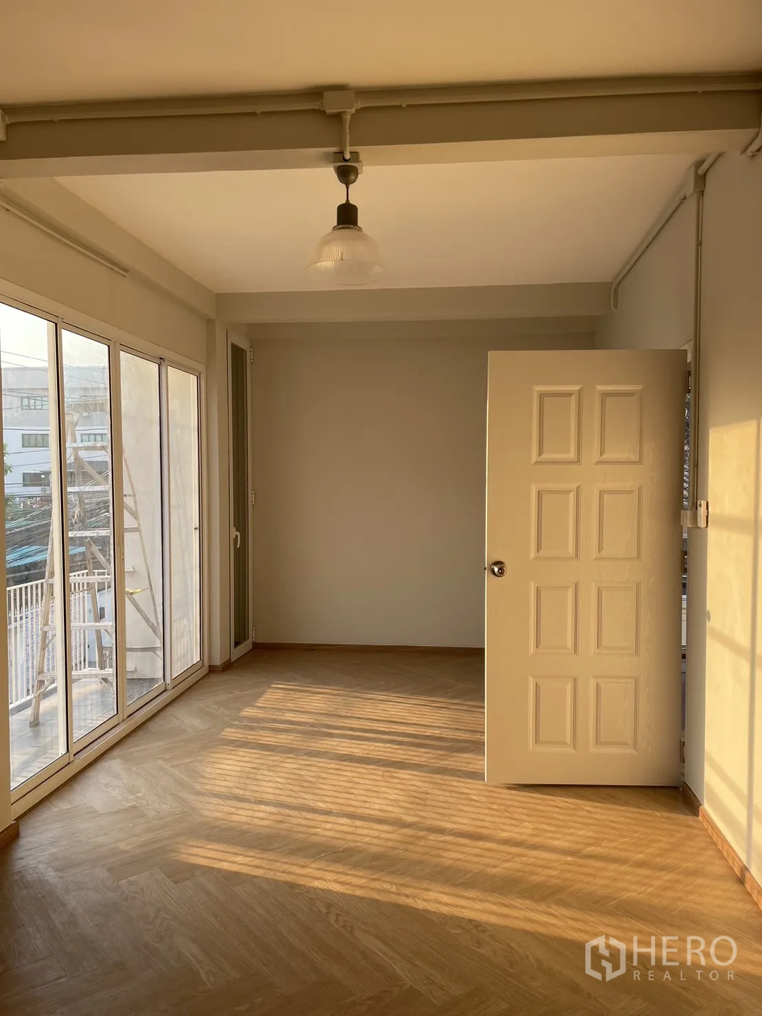 บ้าน ให้เช่าหรือขายในDin Daeng, Bangkok - ห้องนอนชั้นบน ประตูกระจกออกระเบียง แสงบ่ายบนพื้นไม้