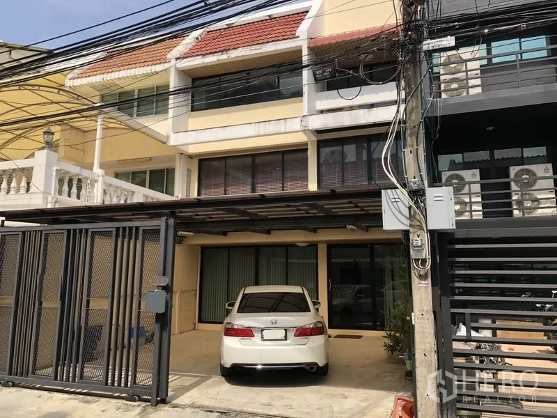 Home Office for rent in Khlong Toei, Bangkok - Three-storey home office facade in Khlong Toei with gated carport and parked sedan.