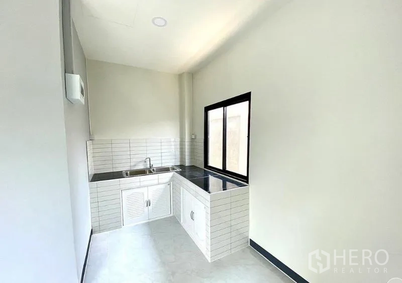 Warehouse for rent in Lat Lum Kaeo, Pathum Thani - Compact pantry with L‑shaped countertop, sink and white subway‑tile backsplash.