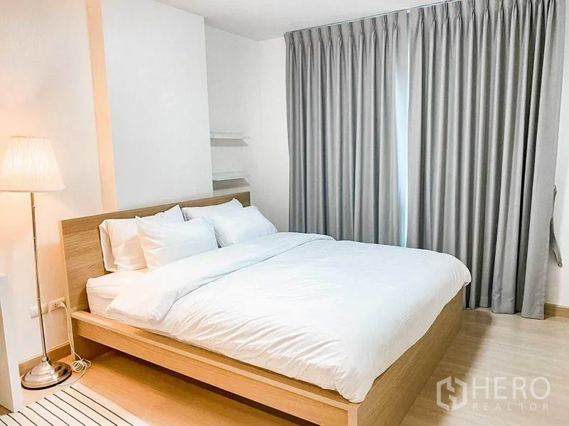 คอนโด ขายในKhlong Toei, Bangkok - ห้องนอนอบอุ่น เตียงไม้ โคมไฟยืน และม่านทึบสูงจรดพื้น