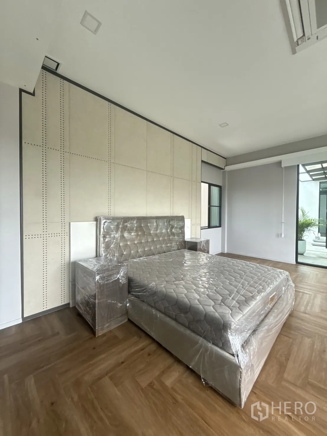 Detached House for rent in Saphan Sung, Bangkok - Detail of upholstered feature wall and bed in a bright modern bedroom.