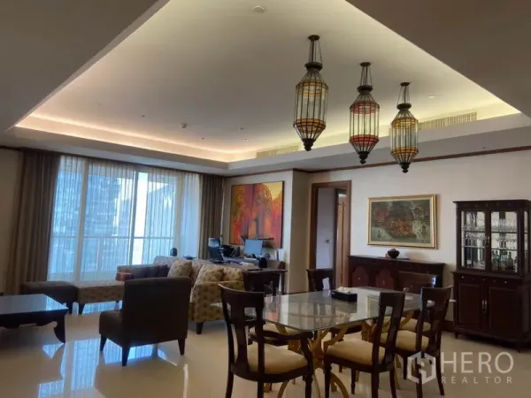 Condominium for rent in Sathon, Bangkok - Open-plan living and dining with lantern pendant lights, large windows, polished floors and classic wooden cabinetry.