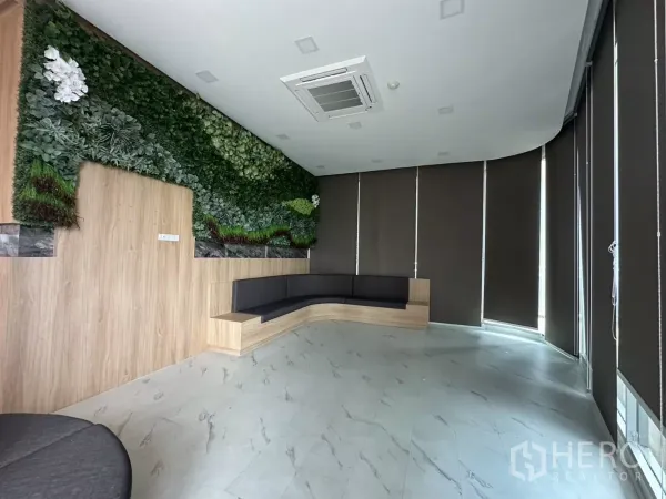 零售空间 出租在Phra Khanong, Bangkok - 精装大堂，绿植景观墙、弧形内置座位，吊顶空调与遮光百叶。